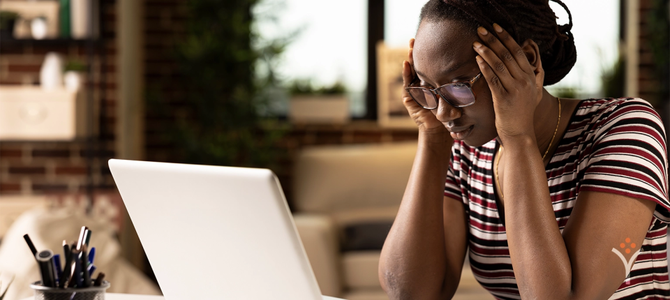 Woman stressed while working on laptop