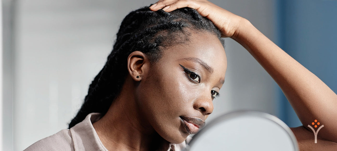 Black woman examining her hairline or scalp